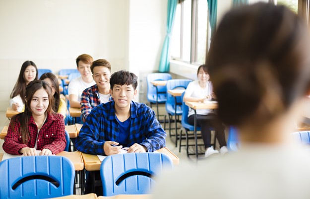 Teacher with  group of college students in classroom
