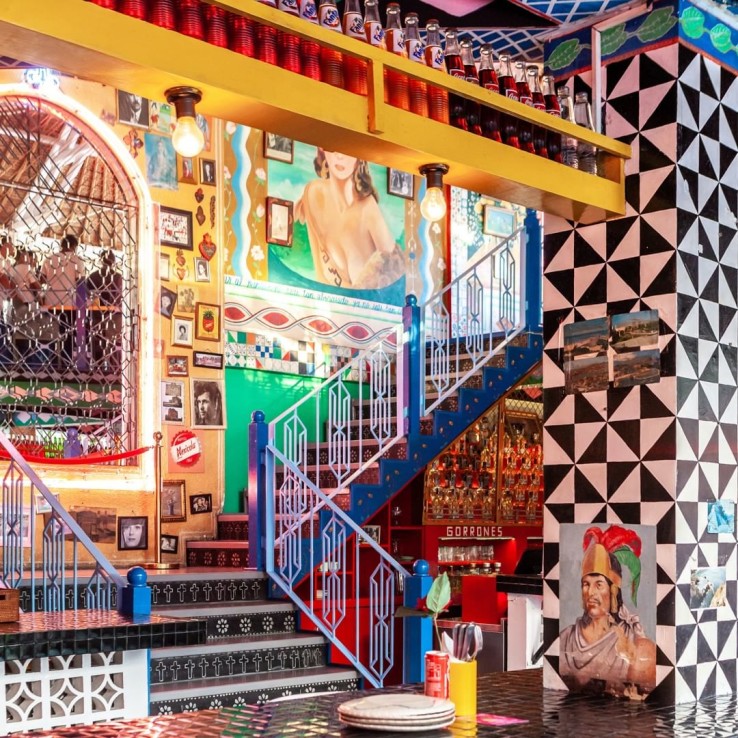 Arsitektur dan interior di Motel Mexicola bergaya Meksiko yang unik, dengan dinding yang dicat warna-warni terang. (Instagram @motelmexicola)