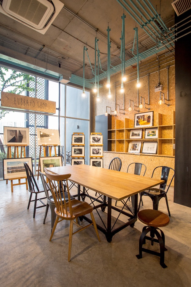 พื้นที่จัดแสดง exhibition และจำหน่ายผลงานศิลป์ที่ HUBBA-TO ร่วมมือกับ blisby.com จัดเรียงผลงานภาพถ่ายอัดกรอบเป็นแกลเลอรีขนาดย่อม ช่วยสร้างชีวิตชีวาให้พื้นที่ชั้นล่างและส่วนของคาเฟ่ไปได้ในตัว