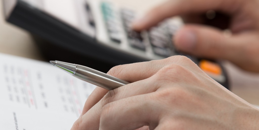 Businessman calculating and checking articles of agreement