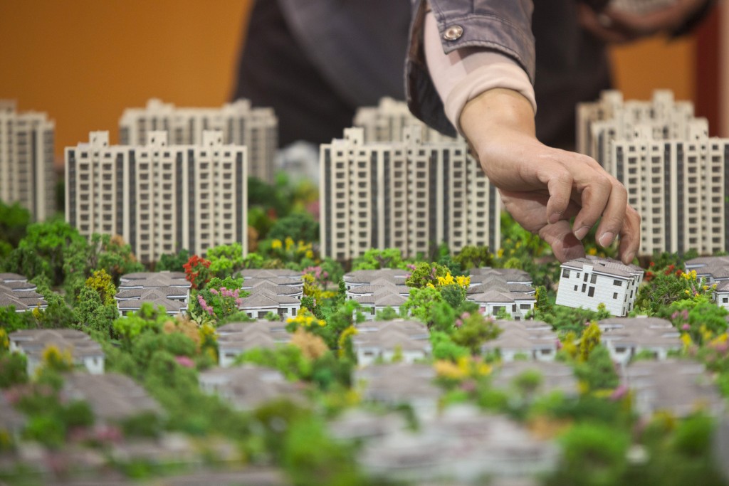 A worker installs models in preparation for a real estate exhibition in Shanghai
