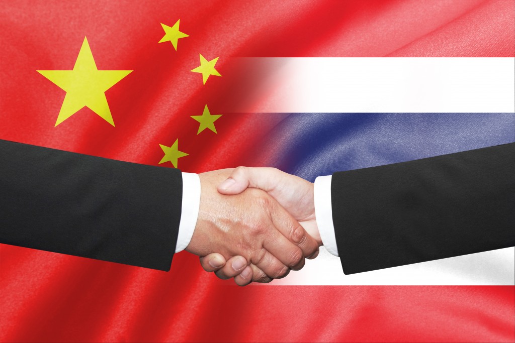 Isolated two business man shakehand over thai and china flag