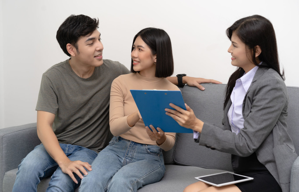 Realtor offer the house and showing detail to customers couple with real-estate agent visiting house for sale