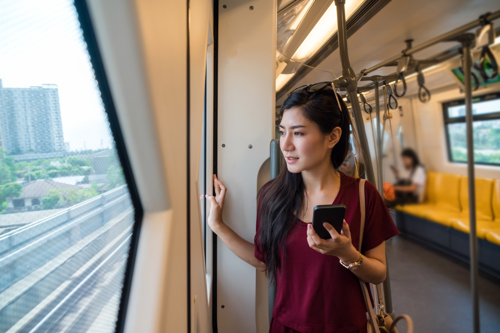 Asian woman passenger with casual suit using smart mobile phone