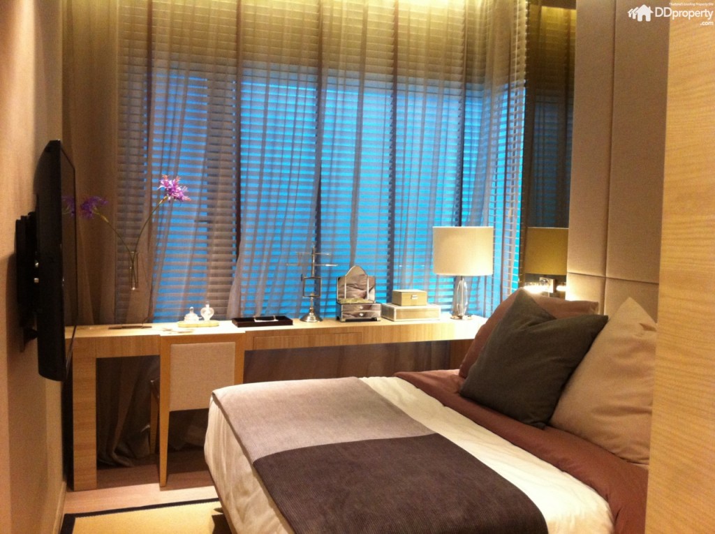 ขณะที่ห้องนอนใหญ่อยู่ถัดจากโซนนั่งเล่นเข้าไปทางด้านในอีก ตัวห้องกรุกระจกเข้ามุมเพิ่มความโปร่งให้กับห้อง