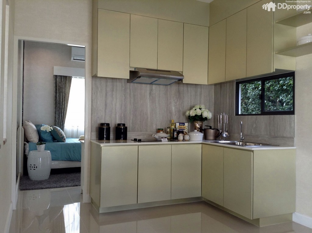 ถัดกันเป็นส่วนครัวบิลท์อิน สามารถกั้นแบ่งพื้นที่บริเวณนี้ด้วยกระจกฝ้า หรือกระจกใสติดสติกเกอร์ขุ่นเพื่อกั้นกลิ่นอาหารรบกวนได้ ส่วนผนังด้านข้างมีหน้าต่างระบายอากาศให้