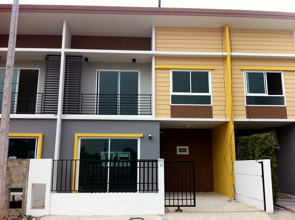 มุมด้านหน้าของตัวบ้าน สเปคที่ได้ตามที่เห็นในภาพ รั้วก่อปูนและประตูเลื่อนเหล็กทาสีดำ