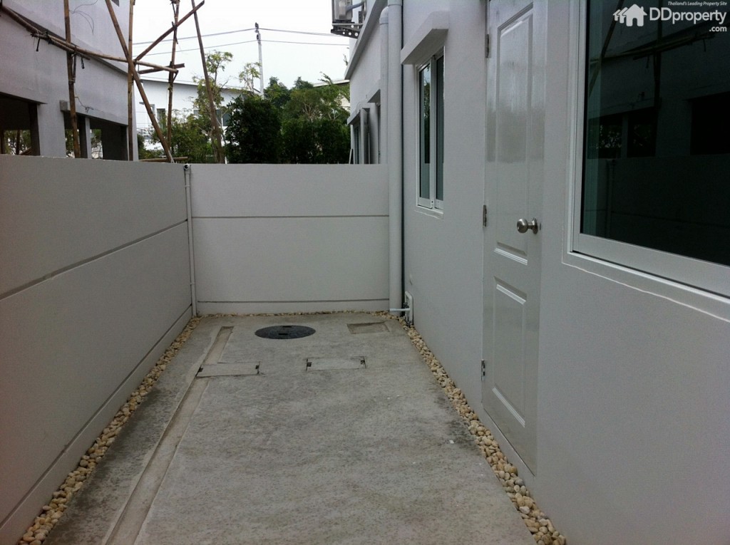 พื้นที่ด้านหลังบ้านเทปูนและโรยก้อนหินให้ตามร่อง