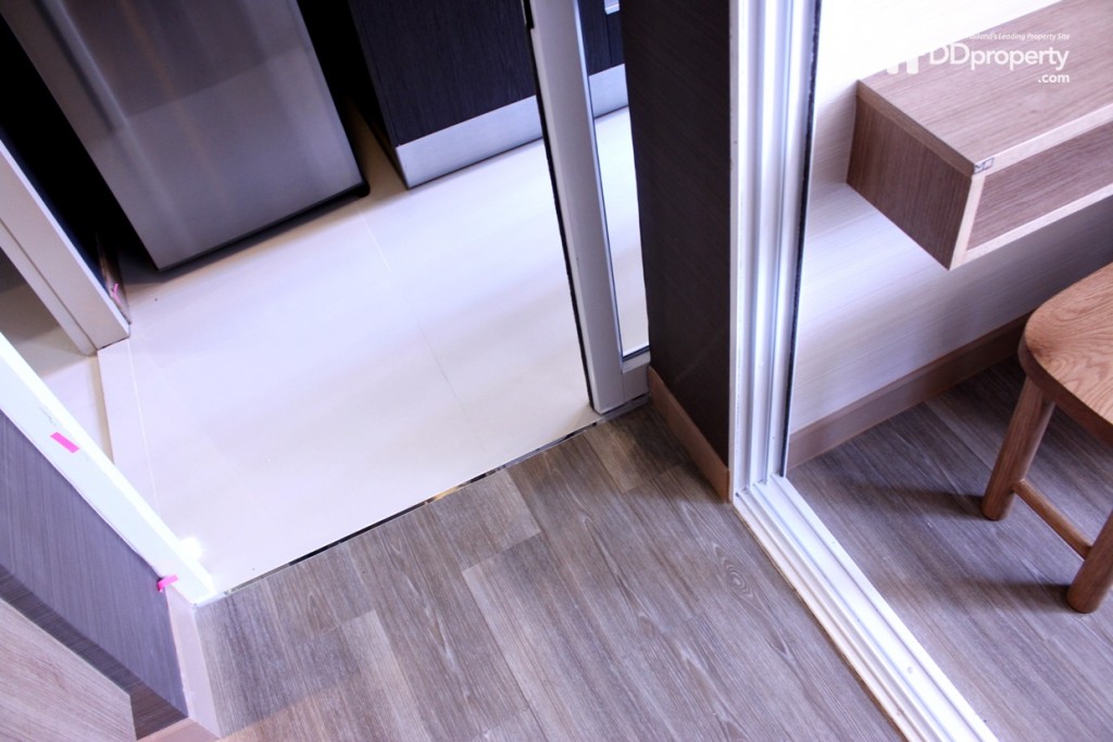 พื้นห้องเป็นไวนิลลายไม้ส่วนห้องครัวเป็นพื้นกระเบื้อง