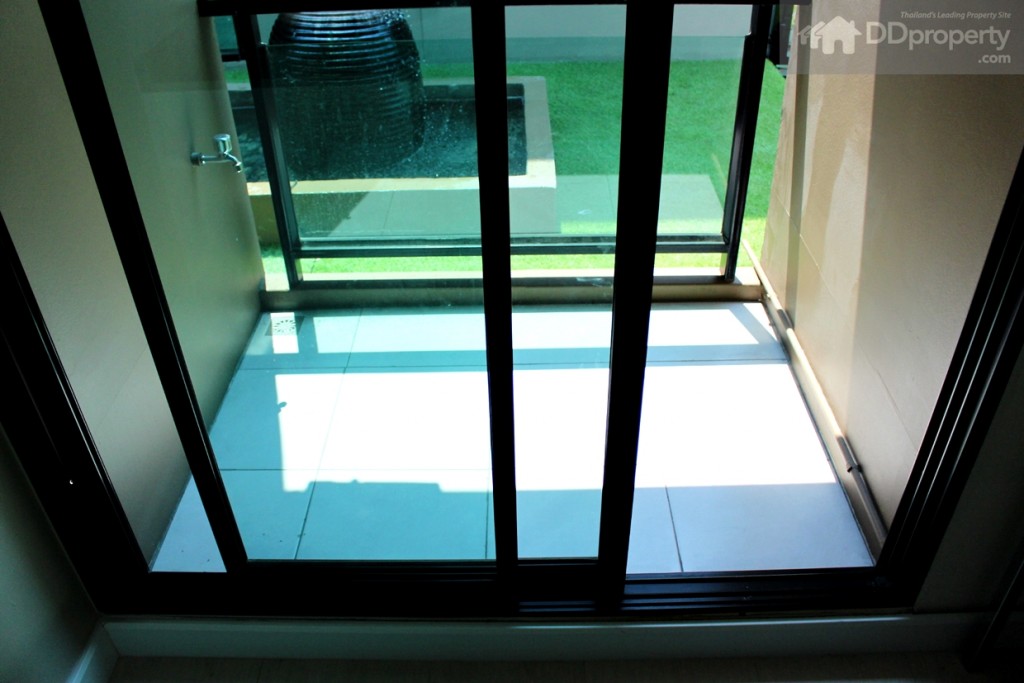 ขนาดระเบียงโดยประมาณ 1.2 x 1.2 เมตร กั้นด้วยการยกขอบ และบานเลื่อน 2 ตอน เป็นกระจกใสสีเขียวตัดแสง ขอบอะลูมิเนียมดำ