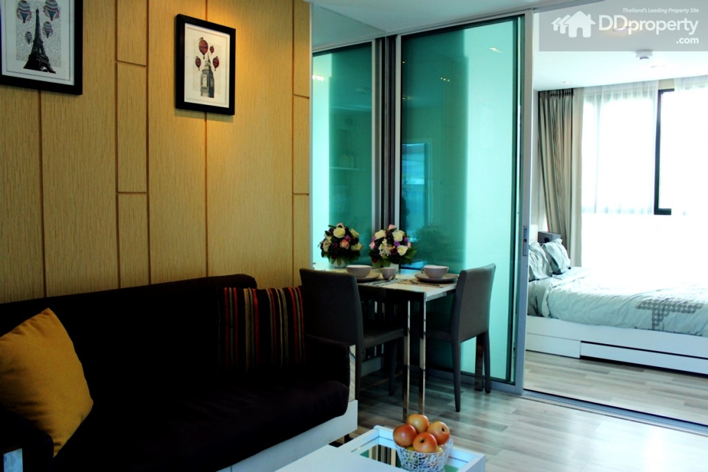 ด้านซ้ายวางโซฟากำมะหยี่ขนาด 2 ที่นั่ง พร้อมโต๊ะกาแฟ ข้างๆโซฟาวางโต๊ะทานข้าวขนาด 2 ที่นั่ง