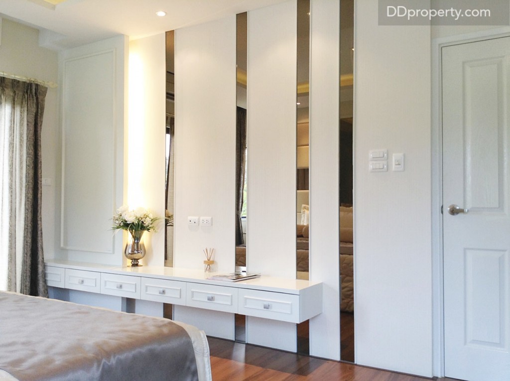 ปลายเตียงแต่งผนังด้วยกระจกเงาเช่นกัน เพื่อให้ห้องดูกว้างขึ้น พร้อมกับบิลท์อินชั้นวางของ และลิ้นชักเก็บของให้ดูเป็นไอเดีย