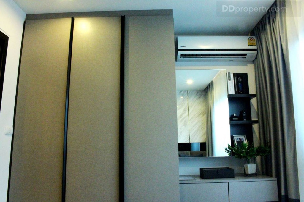 พื้นที่ปลายเตียงเป็นตู้เสื้อผ้า และโต๊ะแต่งห้องที่บิลท์อินมาให้อย่างลงตัว