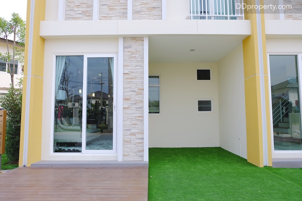 หน้าบ้านของจริงจะให้เป็นพื้นปูนเปล่าไม่มีหญ้าเทียมและพื้นไม้ยางทางเดินดั่งในรูป ประตูเข้า-ออกบ้านเป็นแบบบานเลื่อน