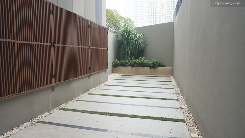 เมื่อเปิดประตูออกมาอีกจะเป็นพื้นที่ลานหลังวิลล่า พร้อมรั้วซีเมนต์ฉาบเรียบสูง 3 เมตร และยังตีระแนงไม้กันเป็นที่เก็บ compressor แอร์อย่างเรียบร้อย 