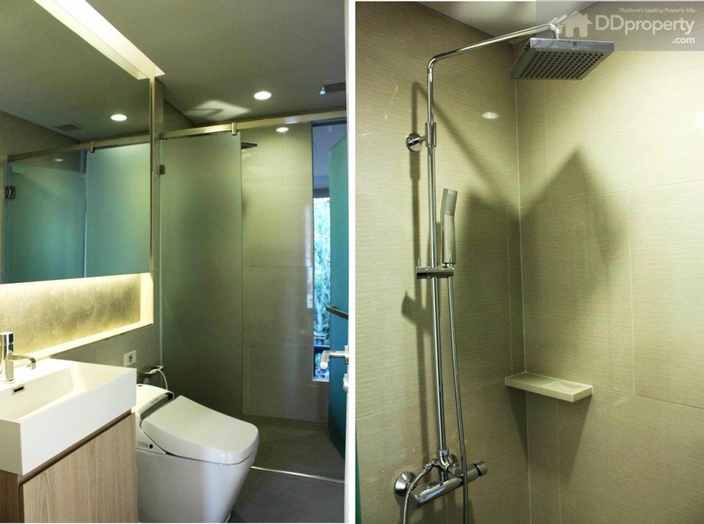 ภายในห้องน้ำมียังคงติดตั้งฝักบัวและเรนชาวเวอร์ขนาดใหญ่ พร้อมแยกส่วนเปียก-แห้งอย่างชัดเจน กระจกกันแบบฝ้า พร้อมที่เก็บของท็อปด้วยกระจกบานใหญ่เต็มพื้นที่ และไฟฝังผนัง