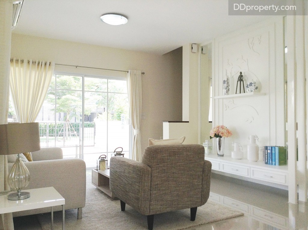 จากมุมรับแขกมองไปยังนอกบ้านผ่านประตูบานเลื่อนขนาดใหญ่ที่เปิดรับแสงสว่างอย่างทั่วถึง