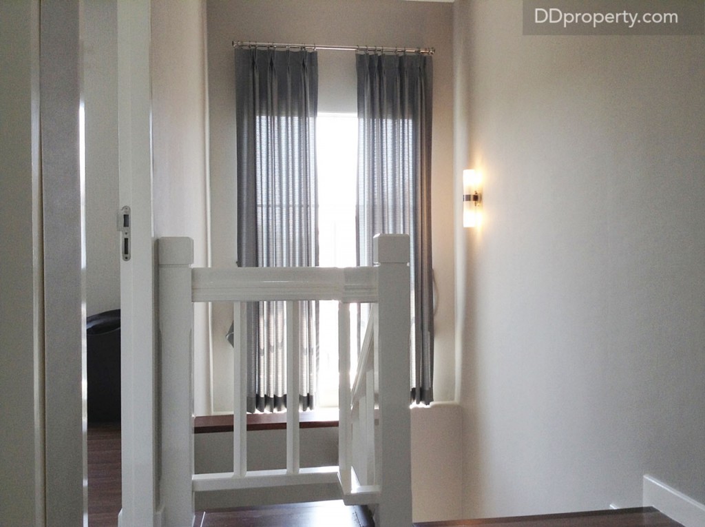 โถงระหว่างทางขึ้นบันได ติดหน้าต่างกระจกบานใหญ่สูงราว 2 ม. ให้ เพื่อเพิ่มช่องแสงให้บ้านสว่าง เพื่อประหยัดไฟในตอนกลางวัน