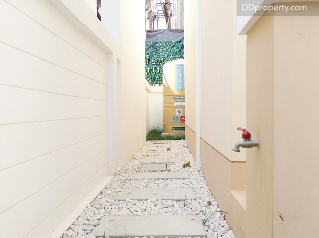 อีกข้างหนึ่งของบ้านตกแต่งพื้นด้วยหินสีขาวไว้เป็นไอเดีย พร้อมติดตั้งก๊อกน้ำไว้ให้เช่นกัน สำหรับล้างรถหรือรดน้ำต้นไม้