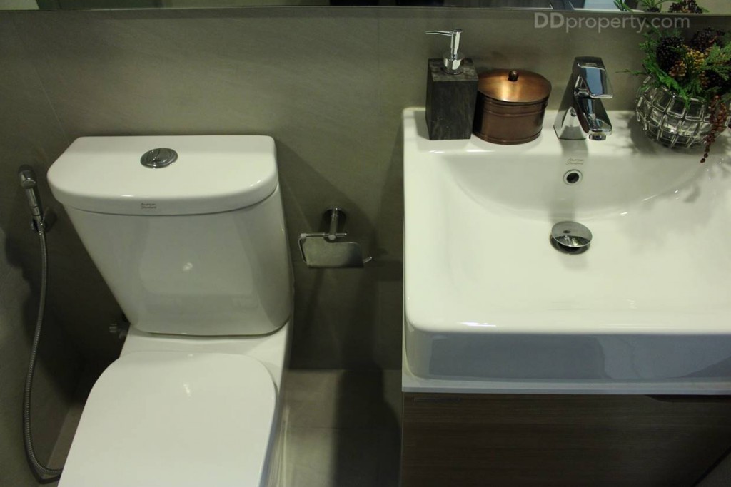 ภายในห้องน้ำรวม ใช้สุขภัณฑ์สีขาวสไตล์โมเดิร์น ของ American Standard ใต้อ่างล้างหน้าบิลท์อินเป็นที่เก็บของ