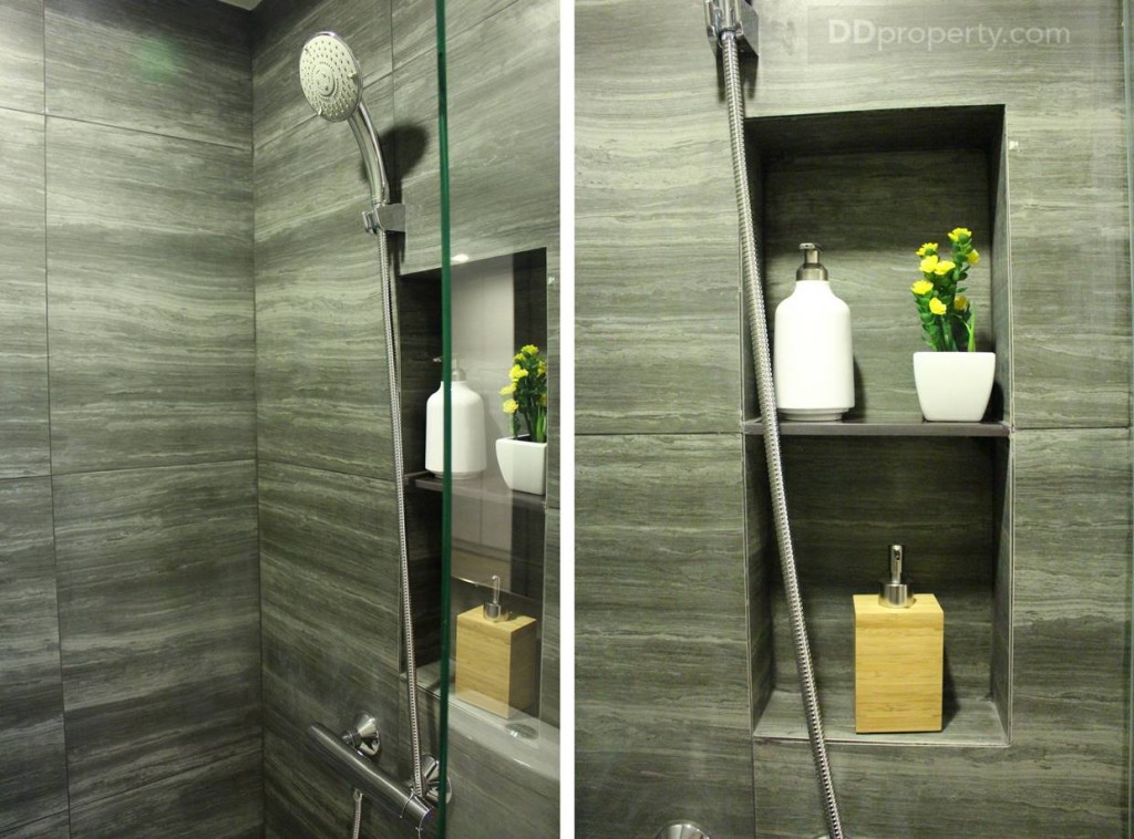 ภายให้ห้องอาบน้ำกั้นด้วยกระจกนิรภัย มีการเจาะผนังเป็นที่วางของ พร้อมด้วยการปูผนังห้องน้ำด้วยกระเบื้องผิวหยาบลายหิน