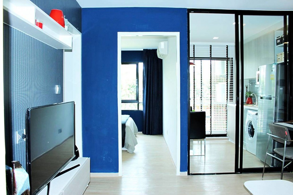 ภาพมุมกว้างของห้องจะทำให้เห็นว่ามีการแบ่งส่วนของพื้นที่ด้านหลังให้เป็นห้องครัว ที่มีฉากกั้นเป็นกระจกเพื่อนำแสงเข้าห้อง แต่ห้องนอนจะเป็นยิปซั่มปิดทึบพร้อมประตูเปิด-ปิดเพื่อความเป็นส่วนตัว