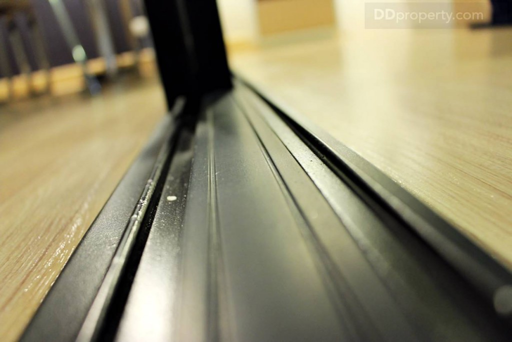 รางเลื่อนของประตูห้องนอนเป็นขอบอะลูมิเนียมดำแบบฝั่งพื้น