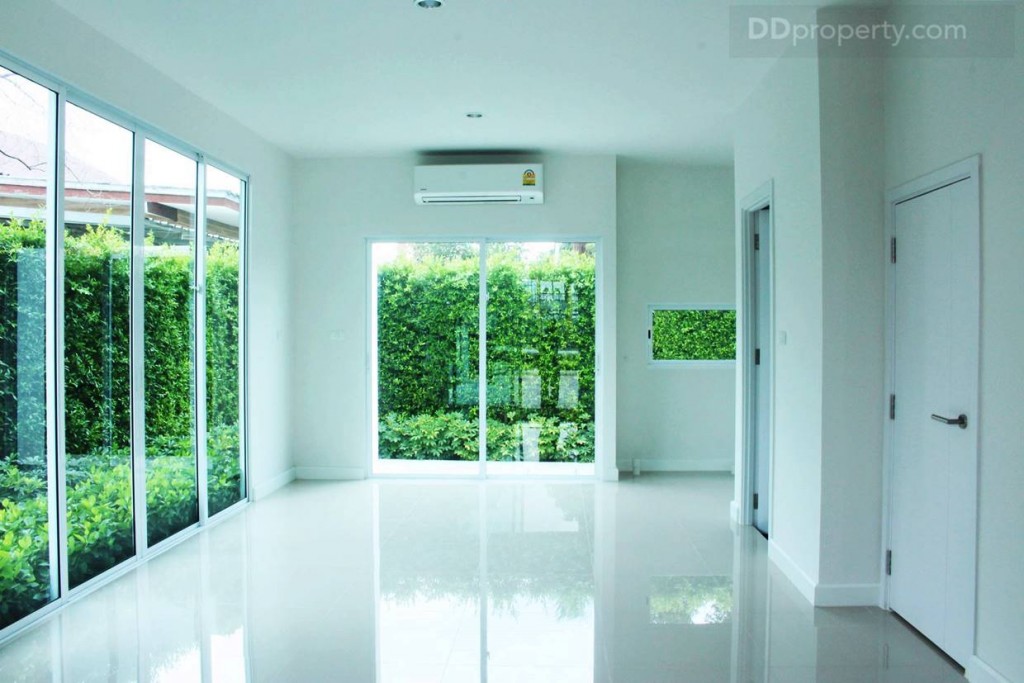 มุมมองภายในบ้านของบ้านเปล่าจากประตูทางเข้า ซึ่งเป็นพื้นที่ของห้องนั่งเล่น ห้องครัว และห้องรับประทานอาหาร