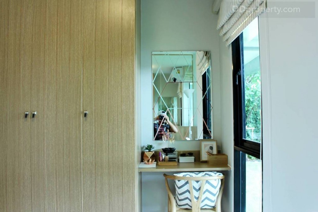 ด้านปลายเตียงเป็นตู้เสื้อผ้าและโต๊ะแต่งหน้าพร้อมหน้าต่างบานกระทุ้งอีกบาน ห้องจริงจะมีแค่หน้าต่างกับผนังฉาบสีขาวเรียบๆ เท่านั้น