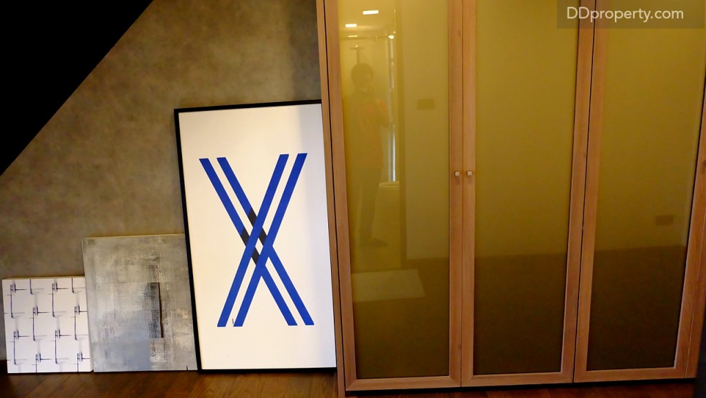 ฝั่งตรงข้ามห้องน้ำภายในห้องนอนนี้ ในบ้านตัวอย่างจะนำตู้เสื้อผ้ามาวาง หากเป็นบ้านเปล่าจะเป็นพื้นที่โล่ง ซึ่งอาจจะนำ props อื่นๆ มาตกแต่งเพื่อไม่ให้พื้นที่ดูโล่งจนเกินไป, ผนังตรงส่วนนี้จะเป็นปูนเปลือย สไตล์ Industrial Loft  เล็กๆ 