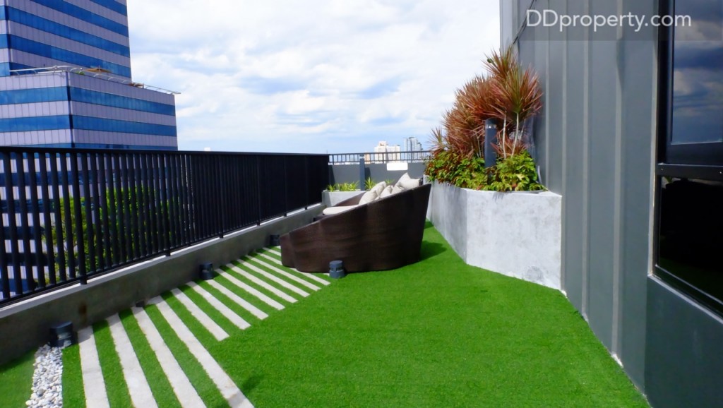 พื้นที่จุดนี้จะมีการปูหญ้าเทียมและหินประดับ พร้อมการจัดวางของโต๊ะเก้าอี้สานและโซฟาเตรียมพร้อมสำหรับรองรับการพักผ่อนของลูกบ้าน