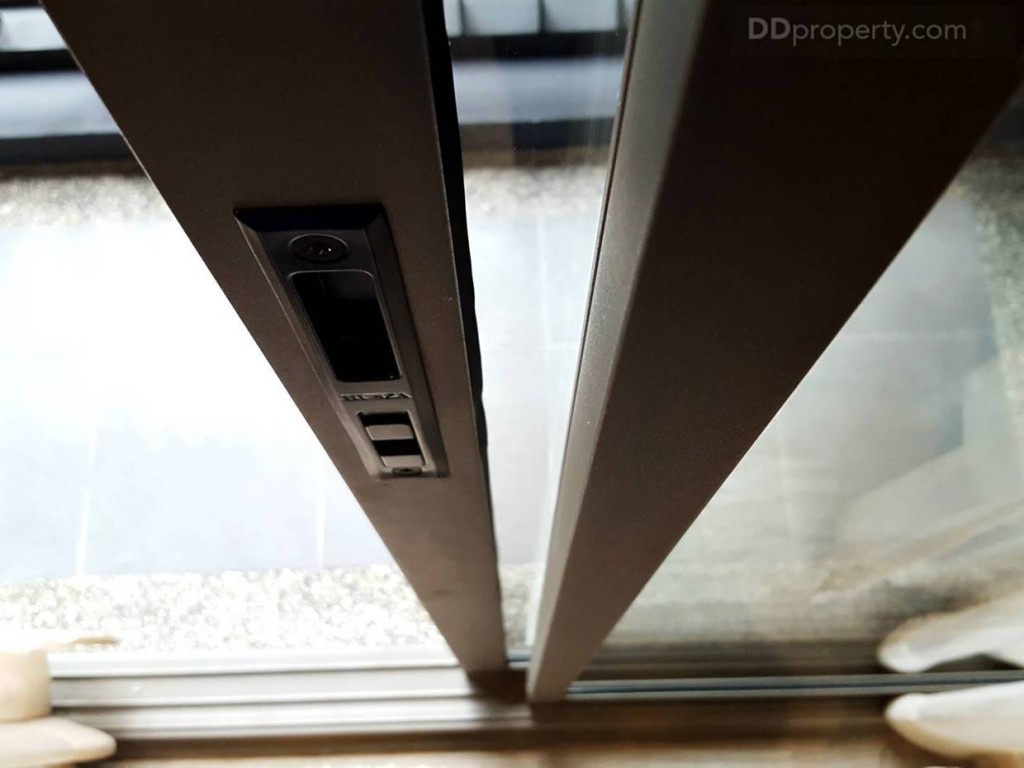 ฉากกั้นระเบียงเป็นกระจกบานเลื่อนแบบ 2 ตอน ขอบอะลูมิเนียมสีเทา ที่จับประตูบานเลื่อนแบบธรรมดา