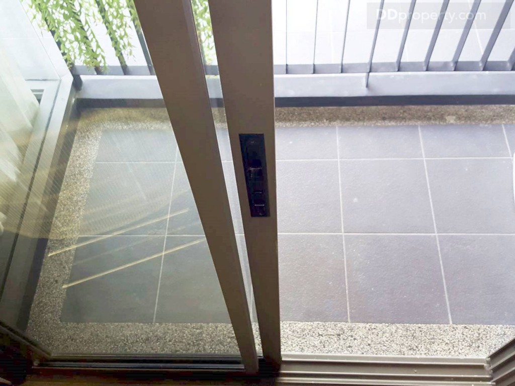 จากครัวเป็นระเบียง กั้นด้วยประตูบานเลื่อน กรอบบานอะลูมิเนียมสีเทาอีกชั้นหนึ่ง