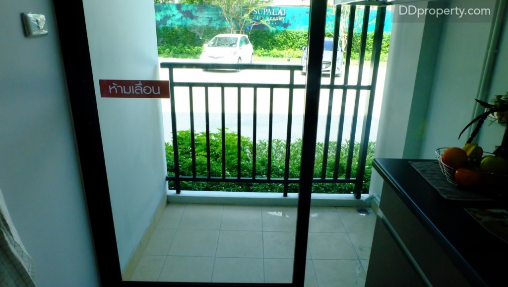 ประตูกระจกบานเลื่อนจากพื้นที่ครัวสู่ระเบียงส่วนตัวขนาดความกว้าง 1 เมตรเช่นเดียวกัน พื้นระเบียงปูด้วยเซรามิก 30 x 30 ซ.ม.