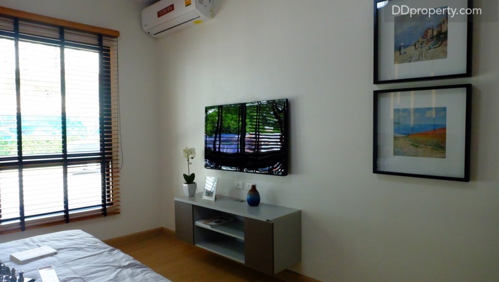 จะเห็นได้ว่าปลายเตียงเหลือพื้นที่อีกมากสามารถจัดวางชุดเครื่องเสียง ขนาดกลาง - ใหญ่ ได้อย่างสบาย สร้างความบันเทิงเล็กๆ ภายในห้องได้  หากเป็นทีวีติดผนังสามารถเลือกได้เลยตั้งแต่ 40 – 50 นิ้ว เนื่องด้วยขนาดห้องที่กว้าง งานบิลท์อินชั้นวางถูกจัดมาให้ด้วยเช่นกัน
