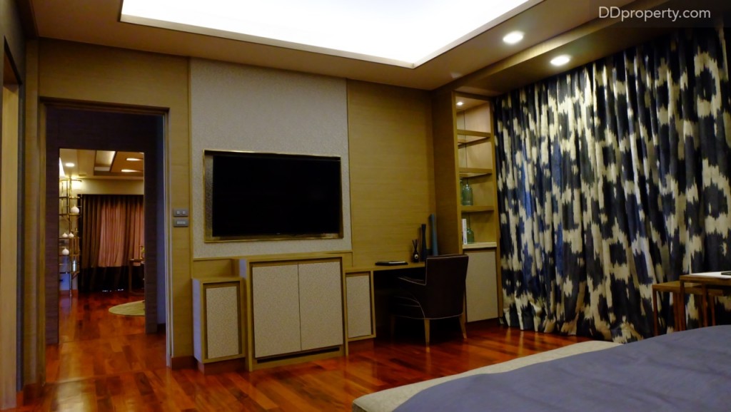 งานบิลท์อินผนังไม้แซมขอบทองเหลือง พื้นที่ปลายเตียงกว้างพอที่จะวางโซฟาขนาดใหญ่ได้อีกสักตัว สำหรับพื้นที่ที่เหลืออาจจะจัดหาชุดโฮมเธียเตอร์ขนาดกลางมาช่วยสร้างสีสีนและความบันเทิงภายในห้อง 