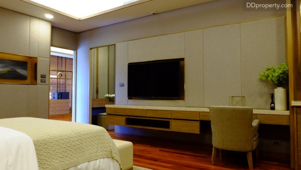 บ้านตัวอย่างบิลท์อินชั้นวางของใต้ทีวีมาให้ สามารถใช้เป็นที่จัดวางชุดเครื่องเสียงขนาดเล็ก – กลางได้ พร้อมเหลือพื้นที่ตรงมุมที่สามารถประยุกต์ใช้เป็นที่นั่งสำหรับวางโน้ตบุคทำงานได้ ผนังด้านหลังทีวี บุด้วยผ้าสร้างจุดเด่นที่แตกต่างจากห้องก่อนหน้า