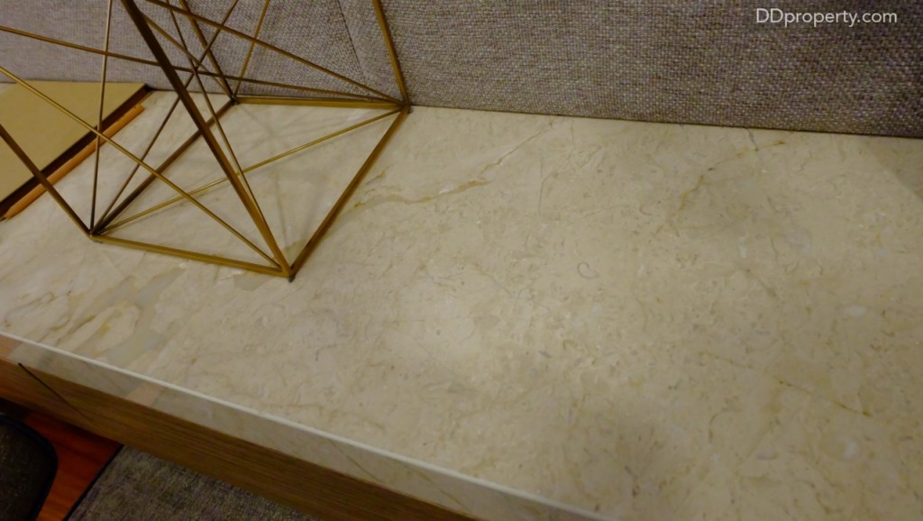 ชั้นวางของใต้ทีวีเป็นงานไม้ที่ท็อปด้วยหินอ่อนสีขาว