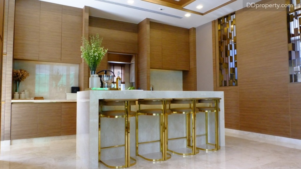 ทางฝั่งขวาเป็นทางเข้าสู่ห้องครัวแต่ก่อนถึงประตูทางเข้าจะมีเคาน์เตอร์หินอ่อนแบบ island ขึ้นมา สามารถใช้เป็นจุดเตรียมอาหารหรือเครื่องดื่มได้ โดยทั้งบ้านตัวอย่างและบ้านเปล่าจะทำการบิลท์อินเคาน์เตอร์นี้มาให้ งานบิลท์อินติดผนังที่ทำจากไม้ด้านข้างหากเป็นบ้านเปล่าจะไม่มี เช่นดียวกับตู้บิลท์อินด้านหลังและเคาน์เตอร์เตรียมอาหารด้านหลัง ที่มีเป็นไอเดียในการตกแต่งในบ้านตัวอย่างเท่านั้น