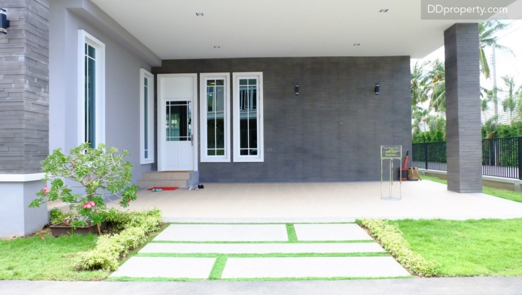 พื้นที่จอดรถหน้าบ้านปูด้วยกระเบื้องเซรามิก 30 x 30 ซม., ผนังเป็นแบบแซนวิชทำจากอิฐมอญประกบฉนวนความร้อนที่ฝังอยู่ข้างใน ทั้งนี้เพื่อการดูดซับความร้อนและเพิ่มความเย็นให้กับตัวบ้านพื้นที่หน้าบ้านสามารถจอดรถได้ 3 คัน