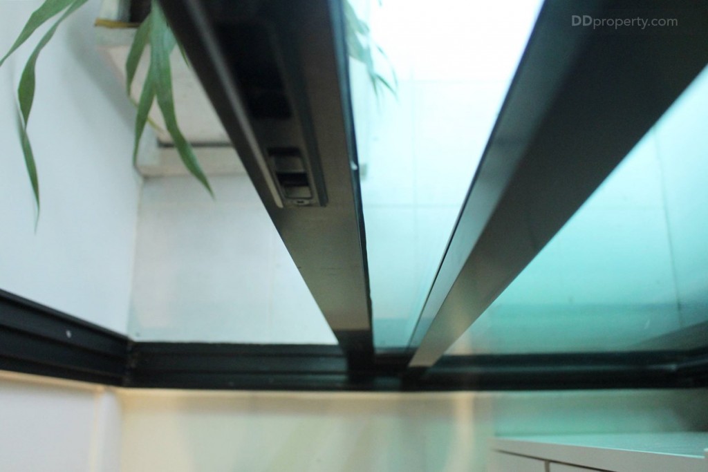 ห้องครัวและระเบียงกันด้วย ประตูกระจกบานเลือนขอบอลูมิเนียมสีดำ แบบ 2 ตอน มีการยกขอบประตูขึ้นมาประมาณ 10 ซม. 
