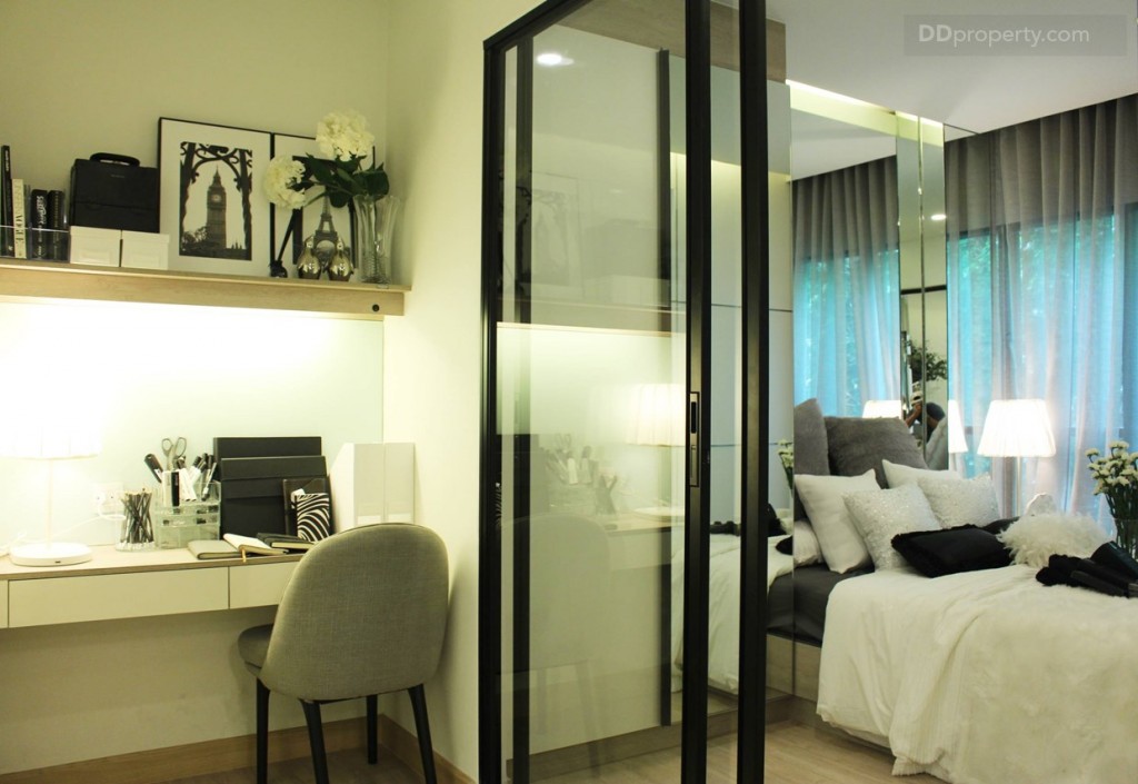 พื้นที่ระหว่างห้องน้ำและห้องนอน ทางโครงการบิวท์อินให้เป็นชุดโต๊ะทำงาน และชั่นวางของอเนกประสงคื