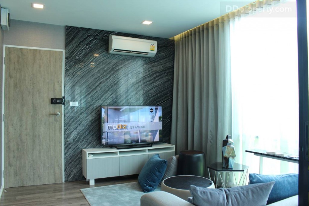 ฝั่งตรงข้ามโซฟาเป็นโต๊ะวางทีวี ช่องรับแสง บริเวณห้องนั่งเล่นที่เปิดมุมมองและทำให้ห้องดูสว่าง ซึ่งภาพรวมห้องนี้ดูกว้างขวางมากทีเดียว