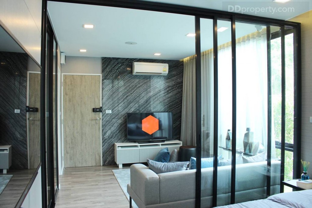 ฉากกั้นห้องเป็นกระจกบานเลื่อนสูงถึงงฝ้าเพดานแบบ 3 ตอน ขอบอลูมิเนียมดำ ด้วยกระจกบานใหญ่ที่สูงถึงเพดาน และความสูงของห้อง 2.4 เมตร ทำให้ห้องดูโปร่ง มากทีเดียว