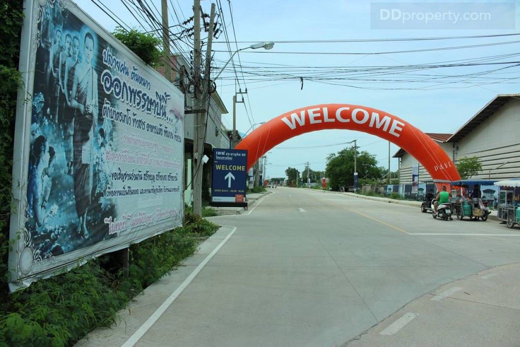 ซุ้มด้านหน้าทางเข้าโครงการอยู่บริเวณทางโค้ง ซึ่งโครงการอยู่ติดกับถนน รพช. – ประชาอุทิศ ซึ่งเป็นถนนตัดใหม่