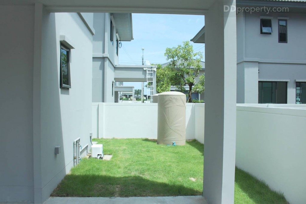 พื้นที่ด้านหลังที่จอดรถมีการปูหญ้าไว้ให้พร้อมให้ถังเก็บน้ำ