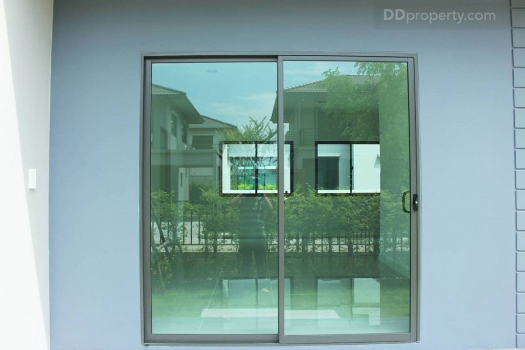ประตูทางเข้าเป็นประตูกระจกใสขอบอะลูมิเนียมสีดำแบบบานเลื่อนแบบ 2 ตอน ขนาด 2 x 2.2 เมตรโดยประมาณ