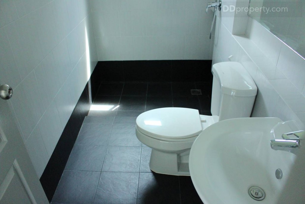 ภายในห้องน้ำปูพื้นด้วยกระเบื้องเซรามิกสีเทาดำ มีทั้งโซนแห้งและโซนเปียกแต่ไม่ได้กั้นโซนไว้ให้