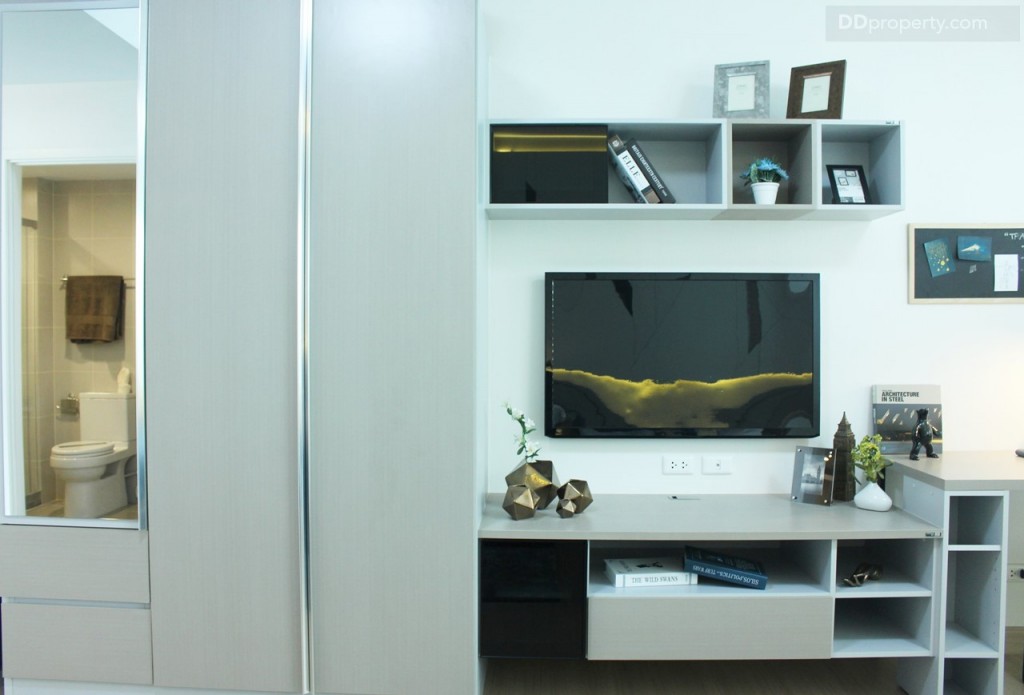 ชั้นวางทีวีสามารถวางชั้นวางทีวีปลายเตียง ขนาบด้วยตู้เสื้อผ้าและโต๊ะทำงาน