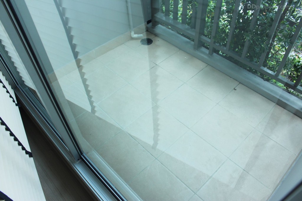 ประตูระหว่างห้องกับระเบียงเป็นกระจกบานเลื่อนแบบ 2 ตอน มีการยกขอบ 10 ซม. ระเบียงกว้างประมาณ 1.2 x 1.65 เมตร